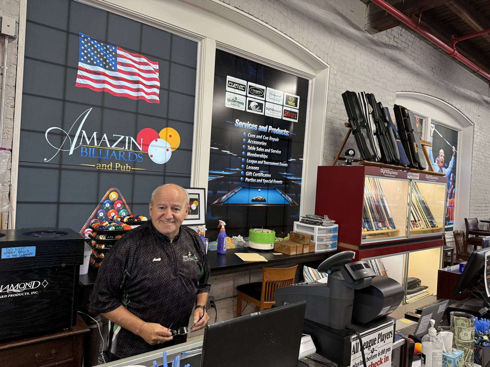 Tom at the Amazin counter with cue cases and the Dynaspheres display