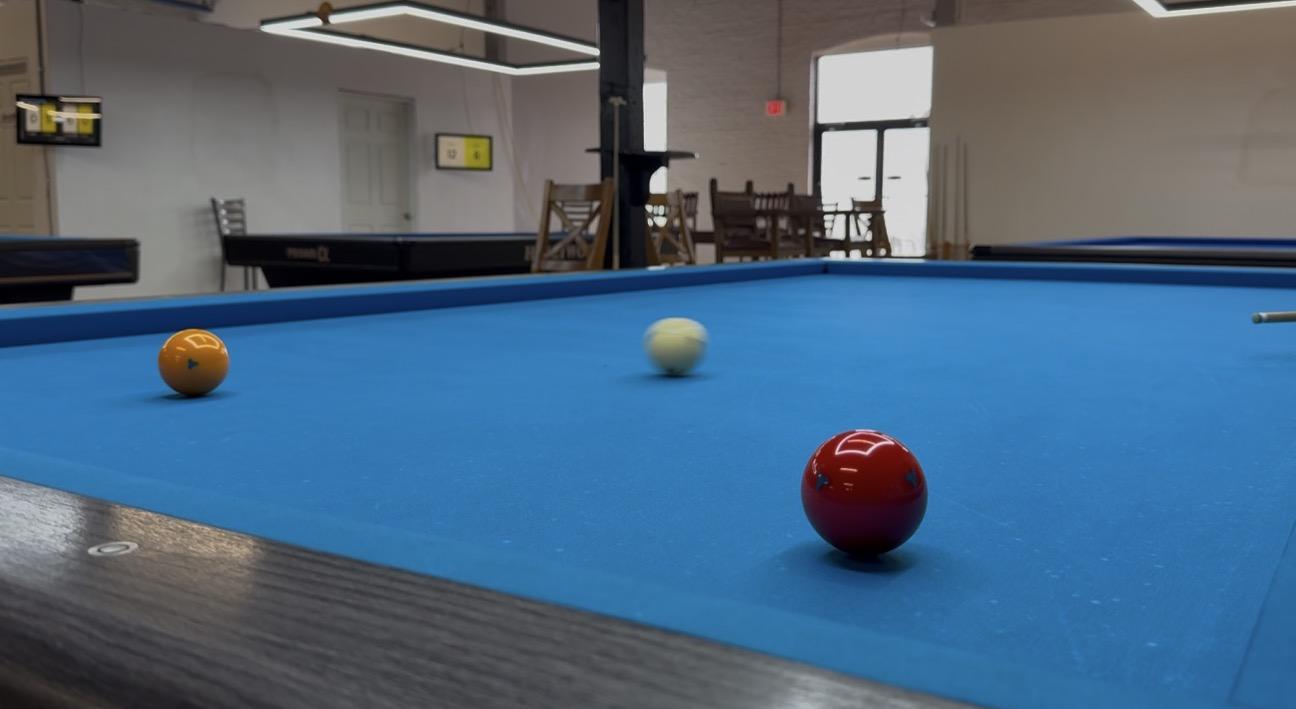 Red, yellow and white carom balls on a heated table