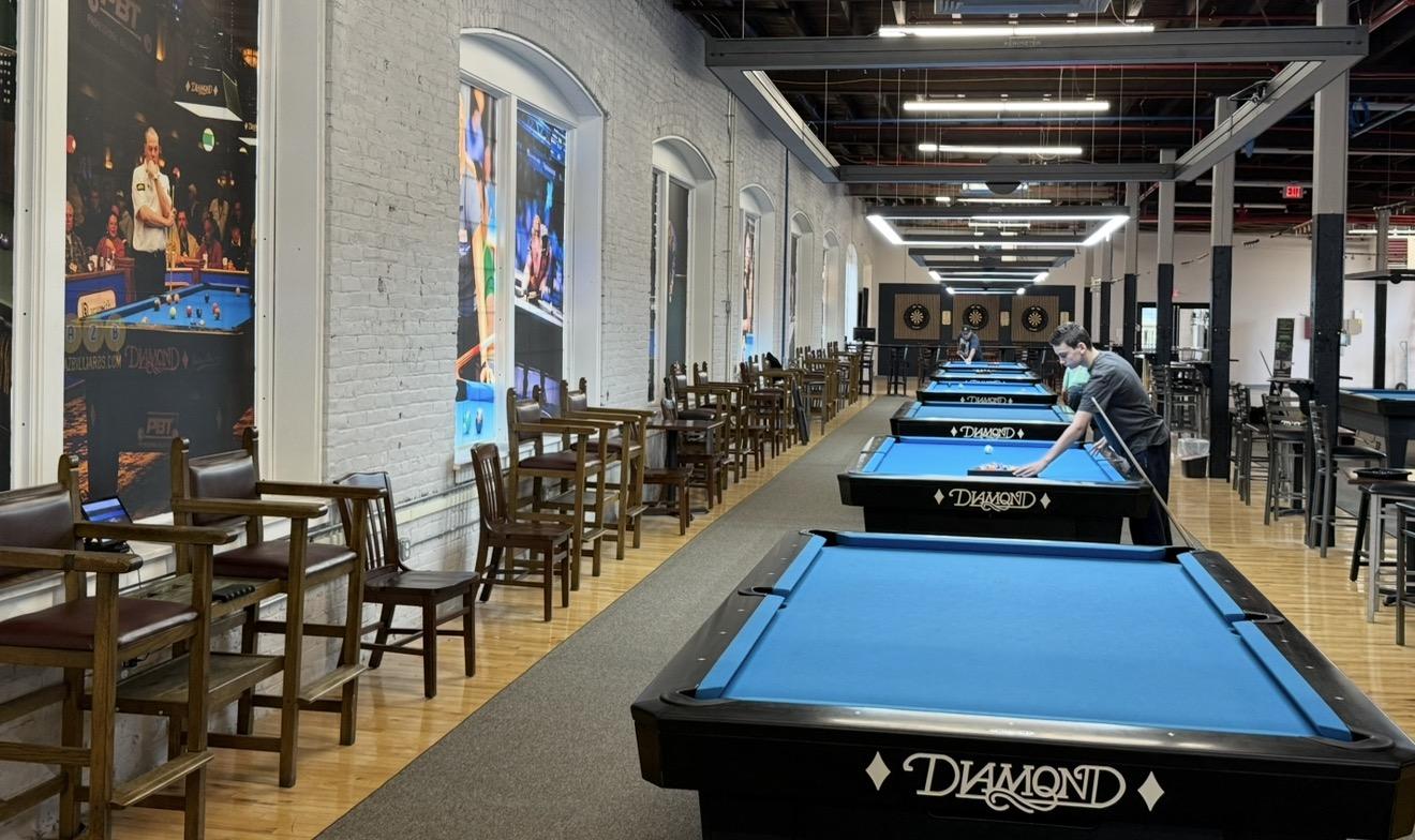 Row of Diamond tables leading to three dart boards