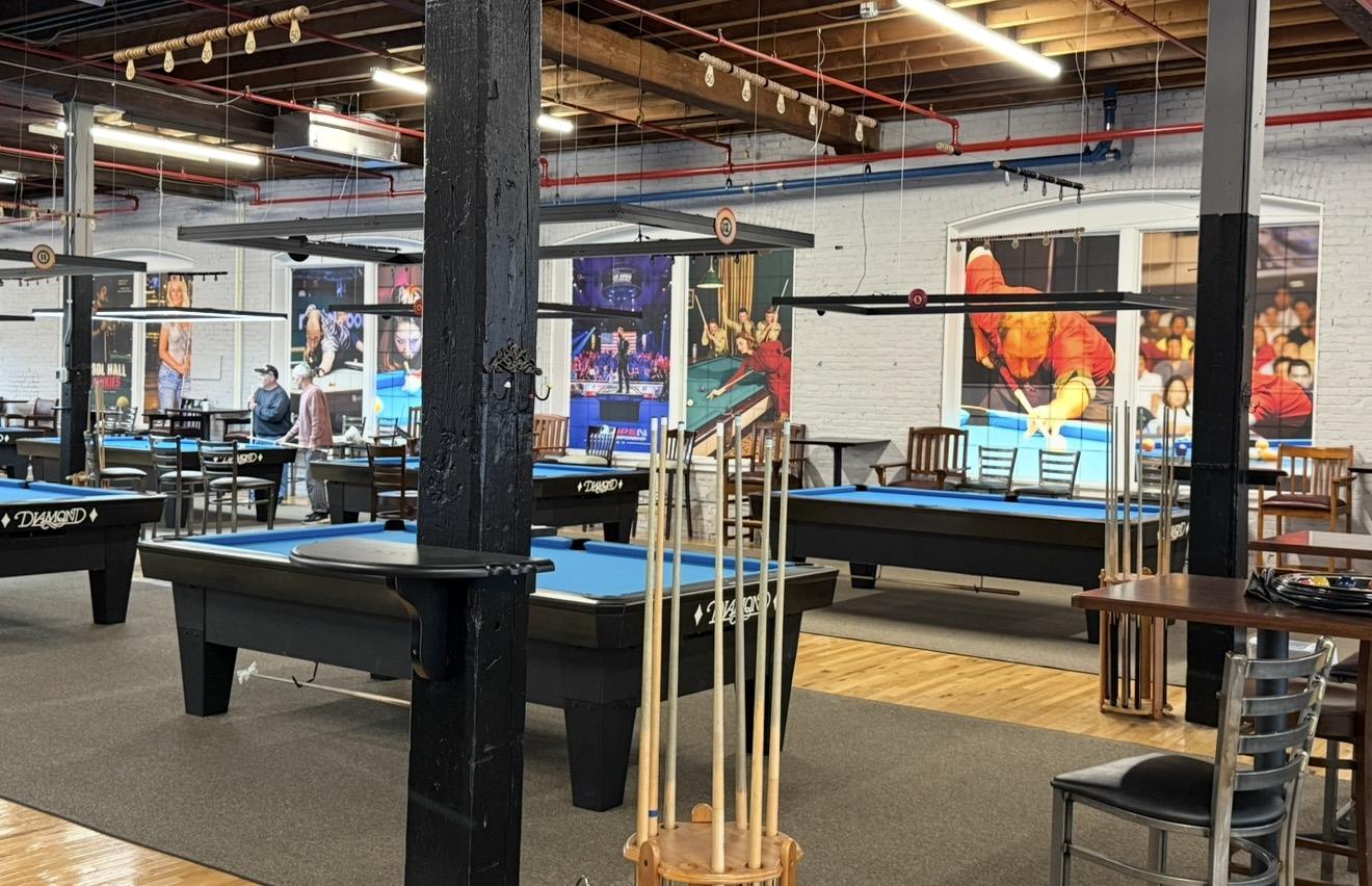 Pool tables in front of large pro player posters